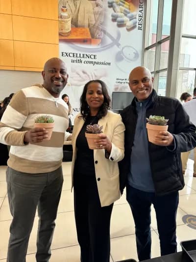 Three guests in a lobby, each holding the plant they potted