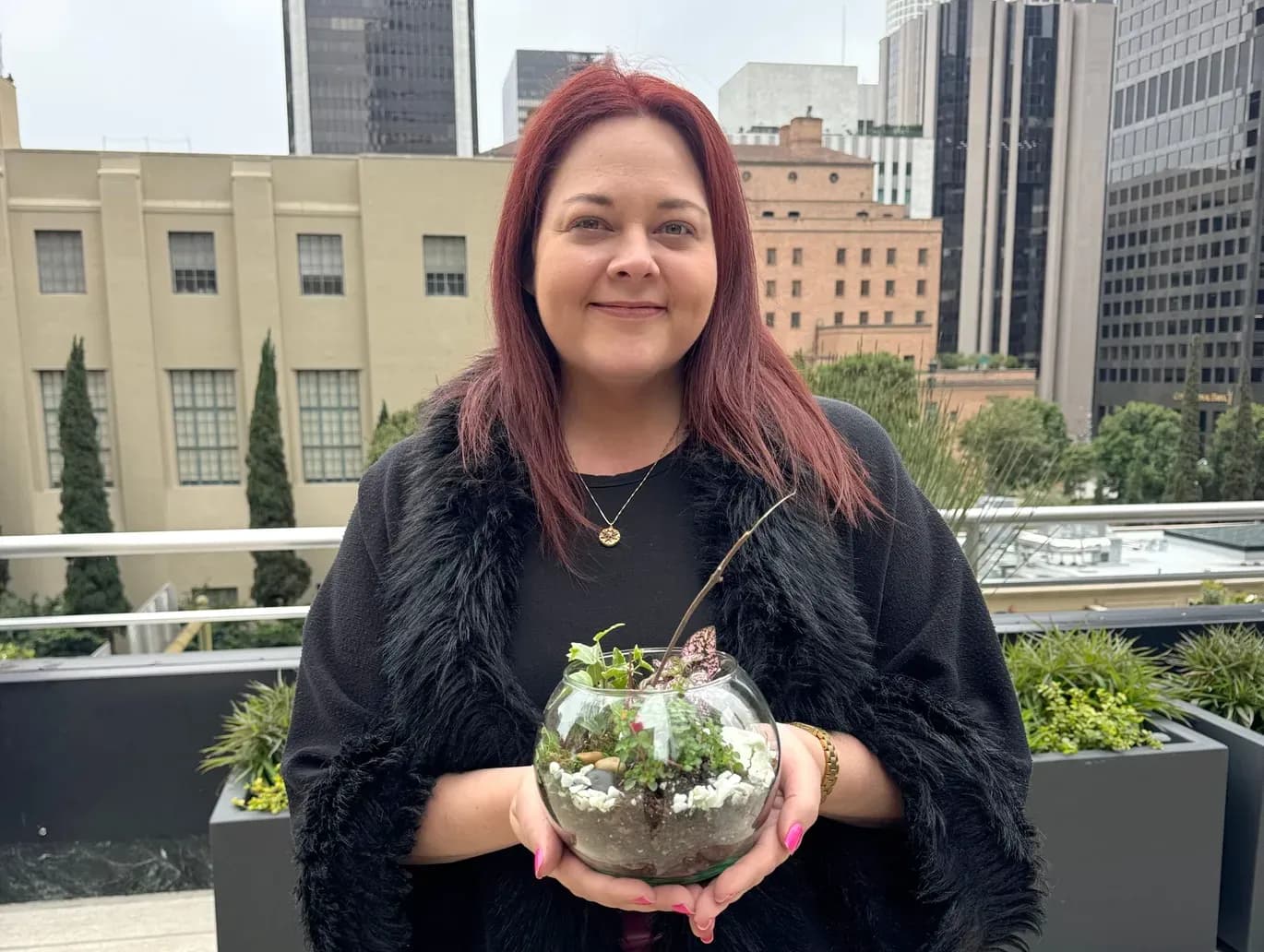 A guest on an office rooftop holding the terrarium she made