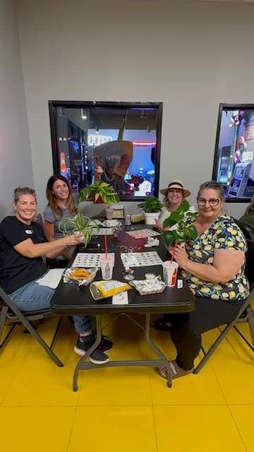 Four Plant Bingo players at the table with their cards and winning plants