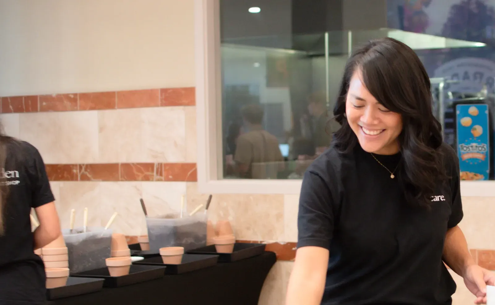 Nerissa smiling as she sets out potted succulents at a make-and-take plant bar