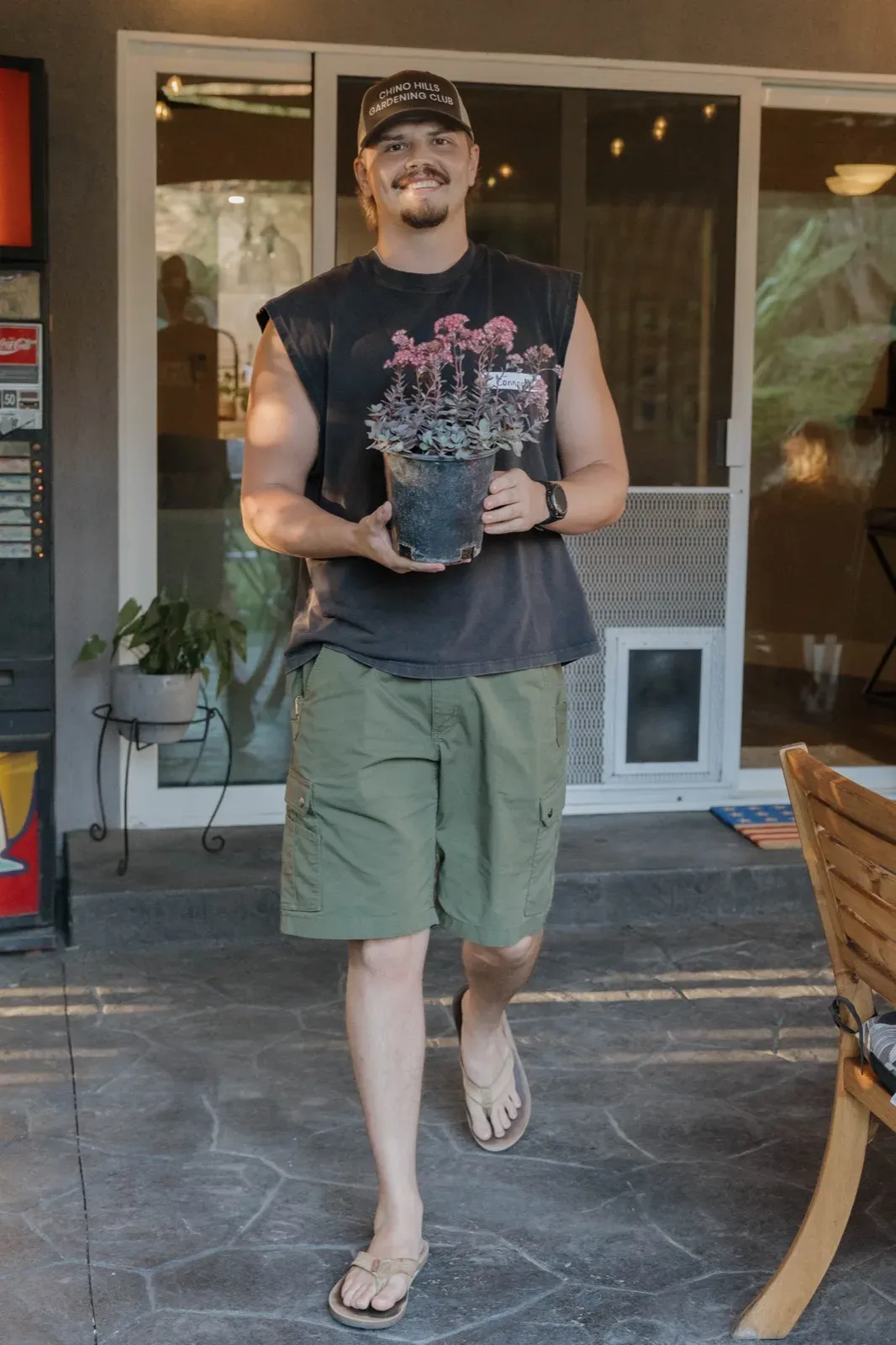 A player carrying away his prize, a potted plant with deep pink foliage
