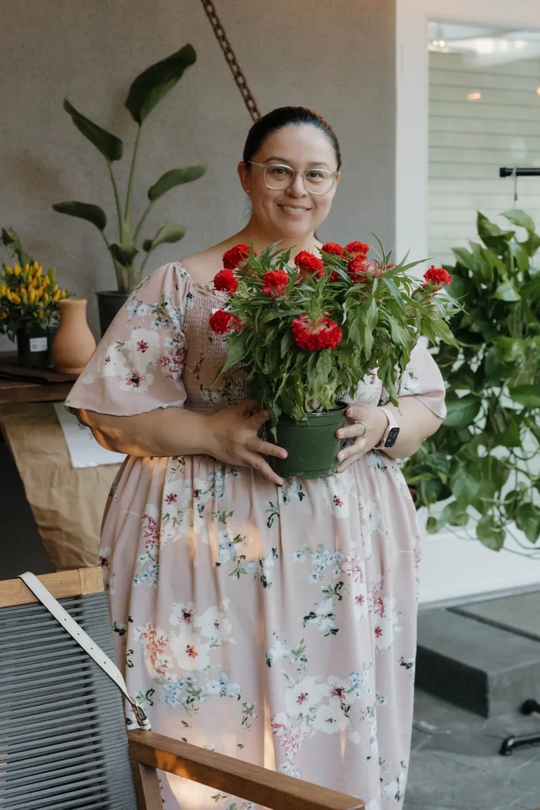 A player holding her prize, a potted plant covered in red blooms
